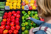 Eine Frau greift nach einem grünen Paprika im Supermarkt. | © Land schafft Leben