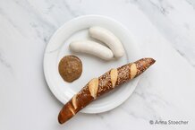 Weißwurst auf Teller mit Senf und Laugenstangerl | © Anna Stoecher
