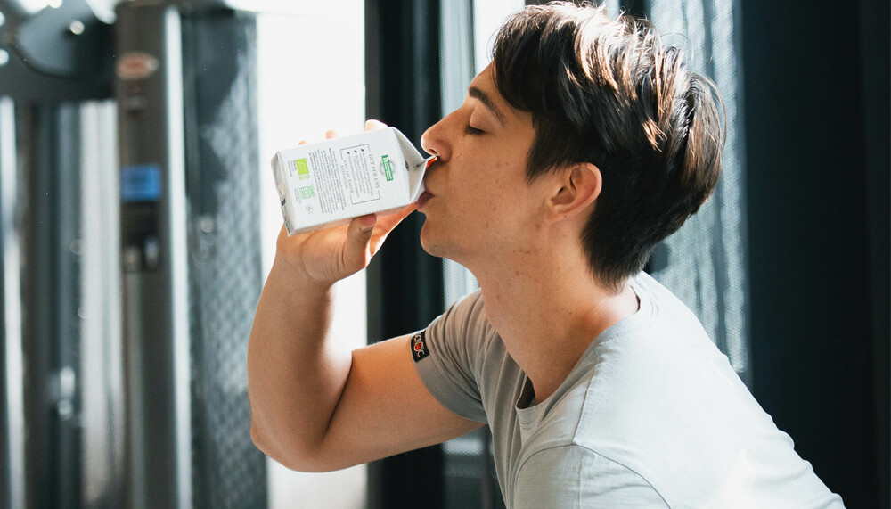 Junge trinkt Buttermilch im Fitnessstudio | © Land schafft Leben