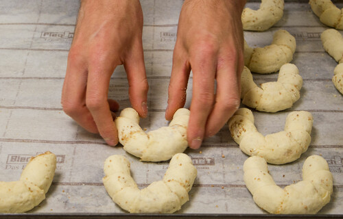 Zuckerbäckerei | © Land schafft Leben Person formt Kipferl auf Backpapier | © Land schafft Leben